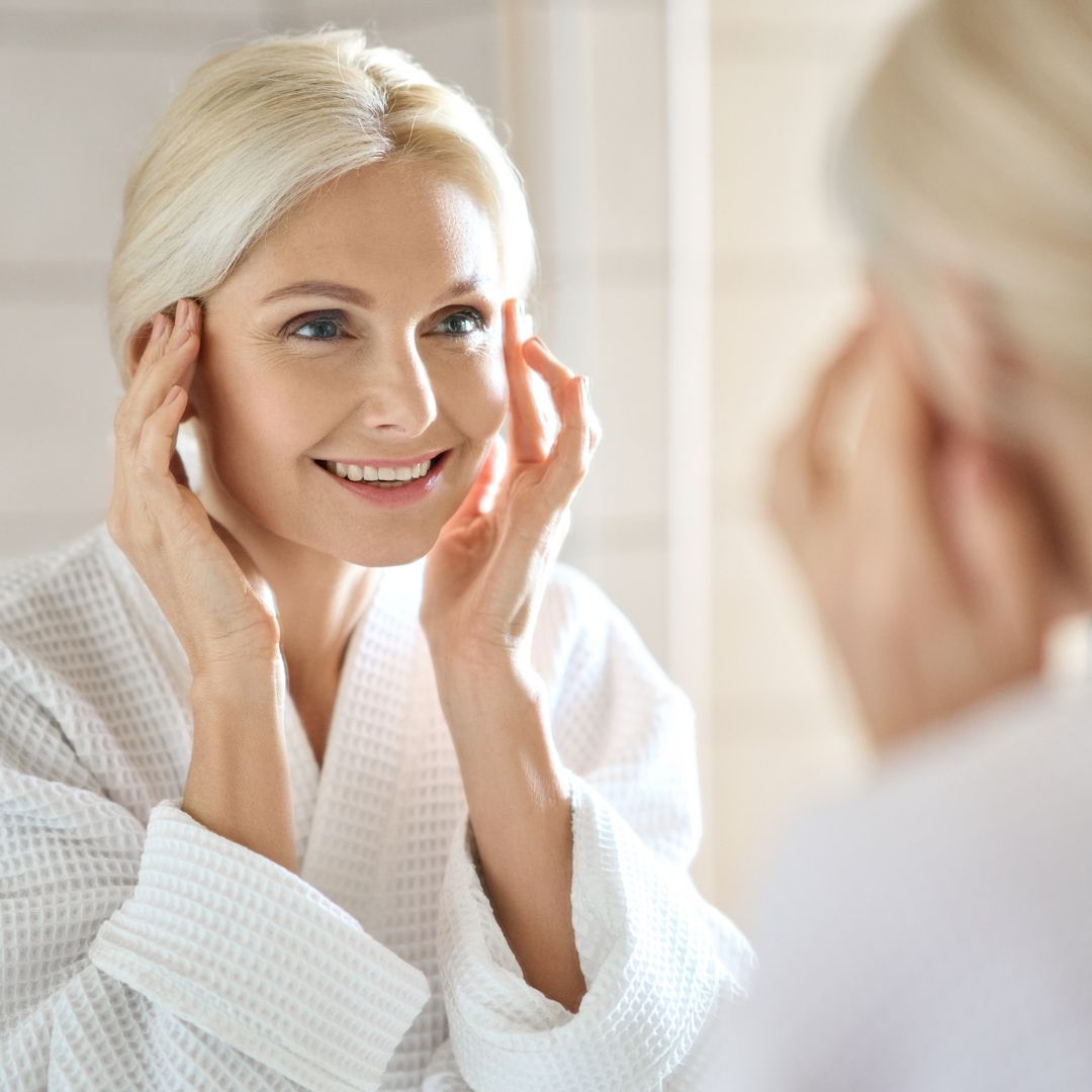 Older woman smiling and looking in mirror