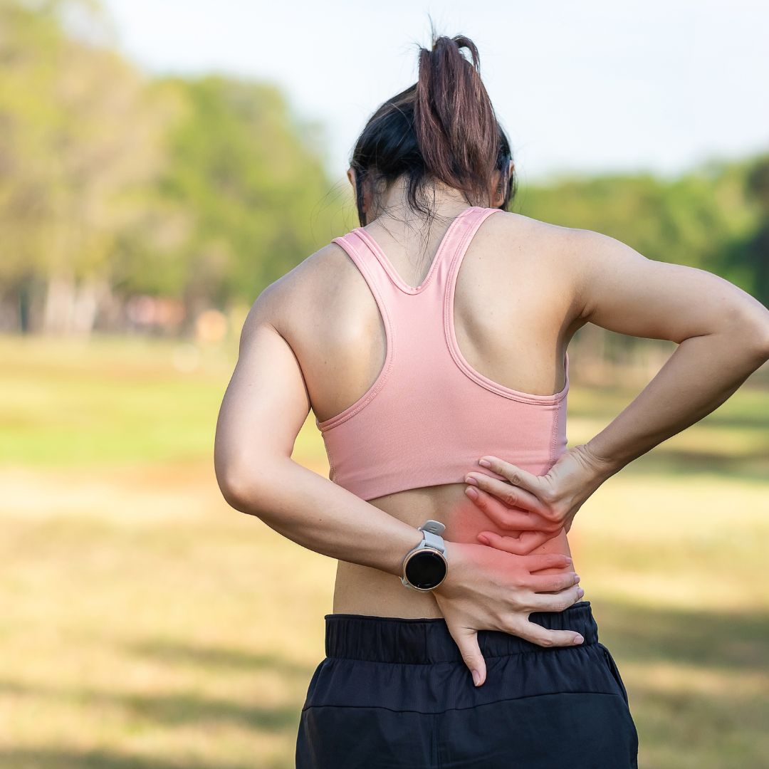 Young woman gripping back in pain