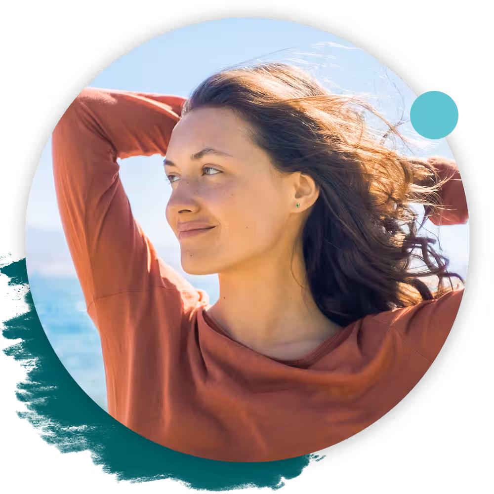 relaxed woman with arms up and windswept hair